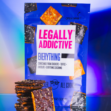 Snack package on blue-purple background labeled 'LEGALLY ADDICTIVE', with stacked chocolate bars in foreground
